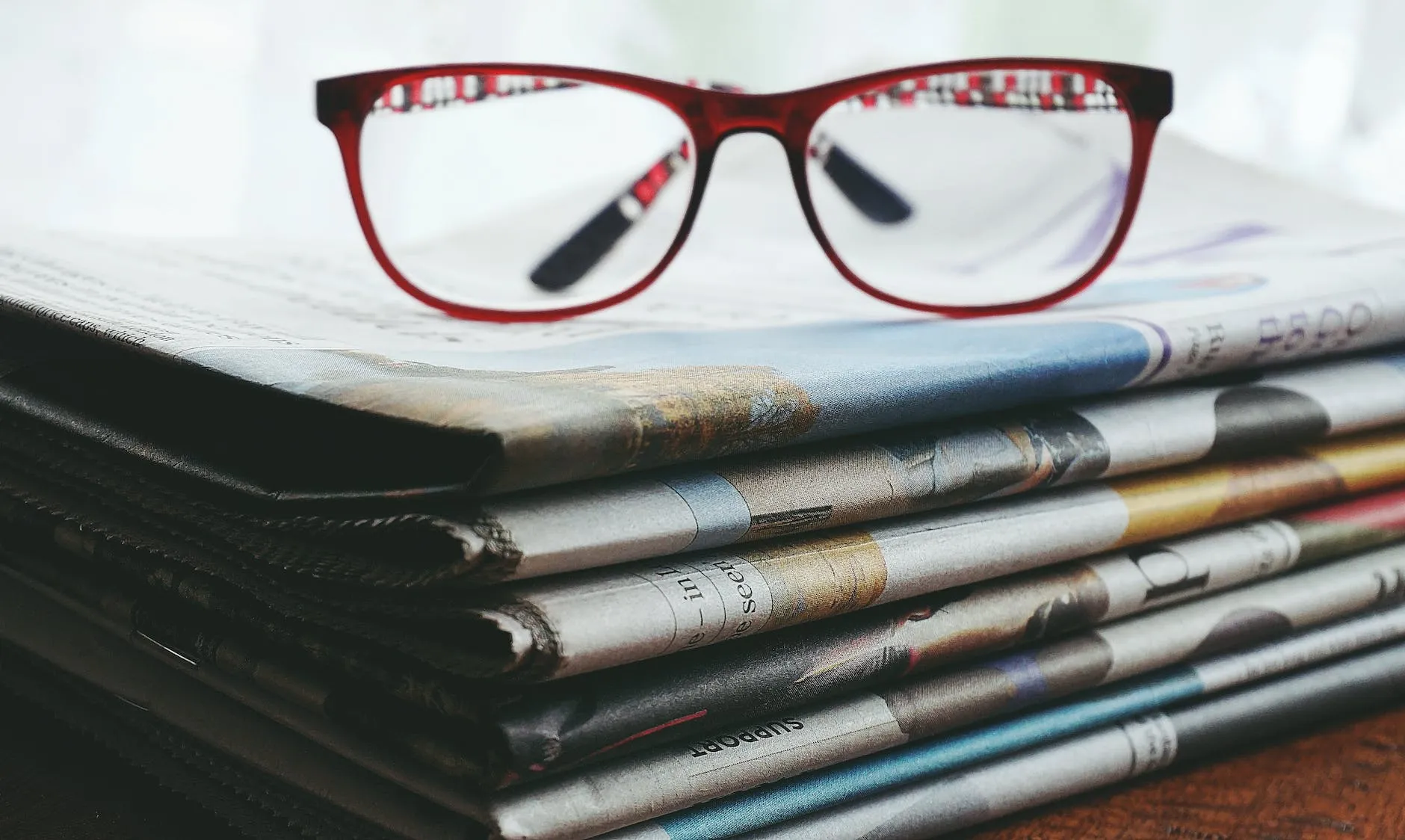 Lunettes à monture rouge sur les journaux